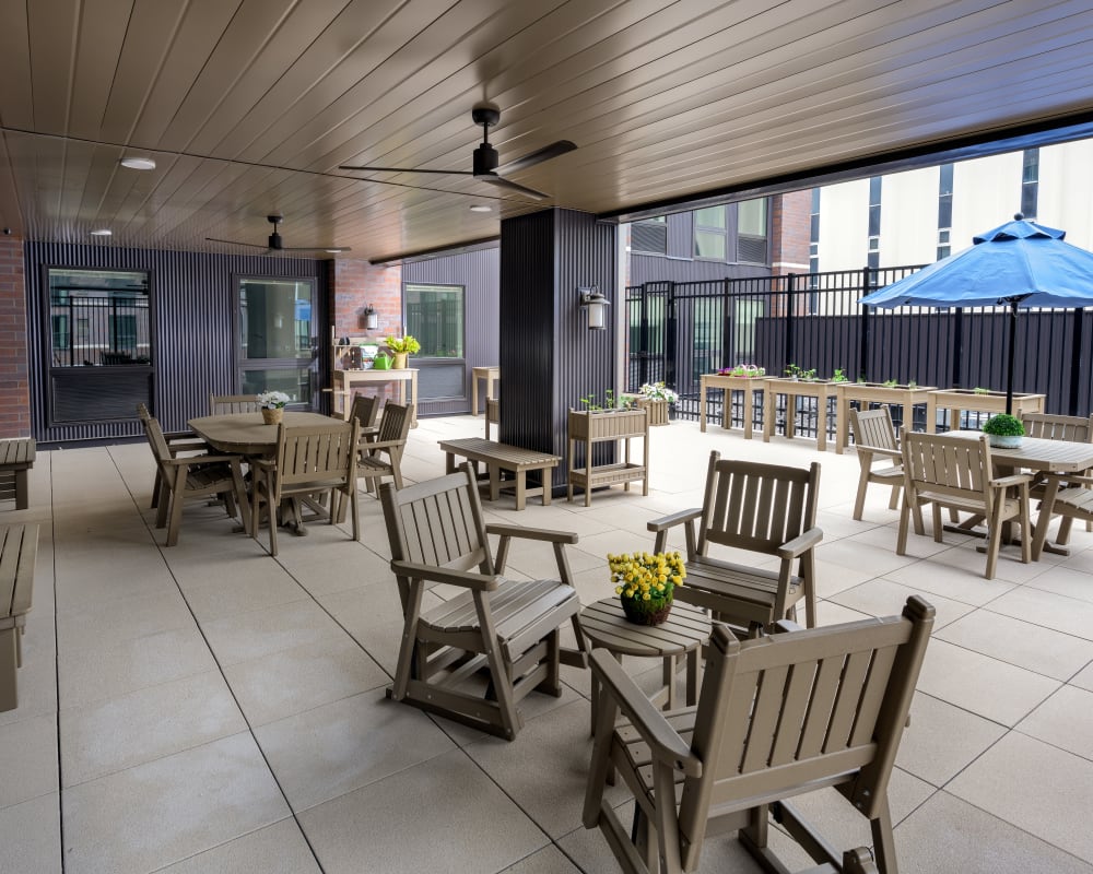 A covered outdoor patio with tables and chairs at The Pillars of Prospect Park in Minneapolis, Minnesota