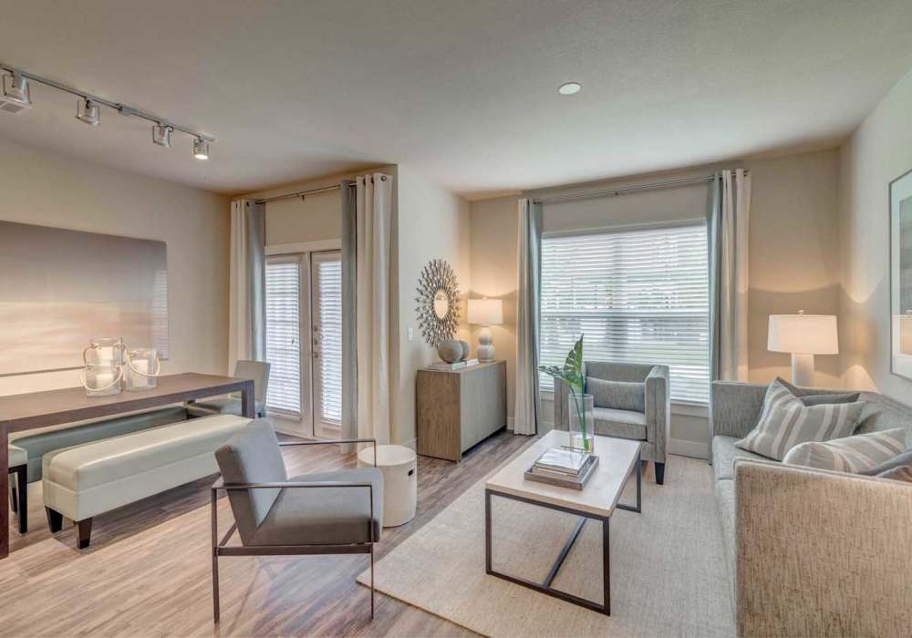 Living room with sofa, armchair, coffee table and track lighting at Southfork Lake in Manvel, Texas