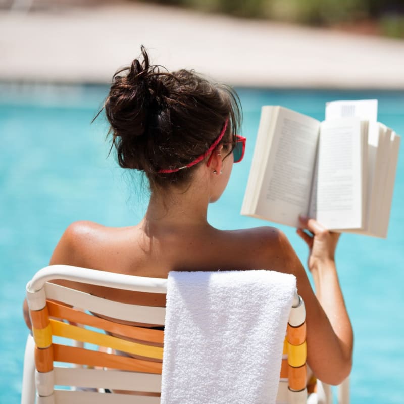 Resident reading a book on the pool at Senita on Cave Creek in Phoenix, Arizona