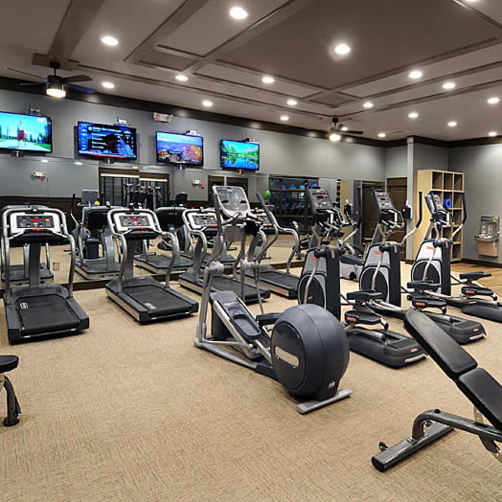 Modern fitness center with high-end equipment and multiple screens at Avonlea Square in Smyrna, Georgia.