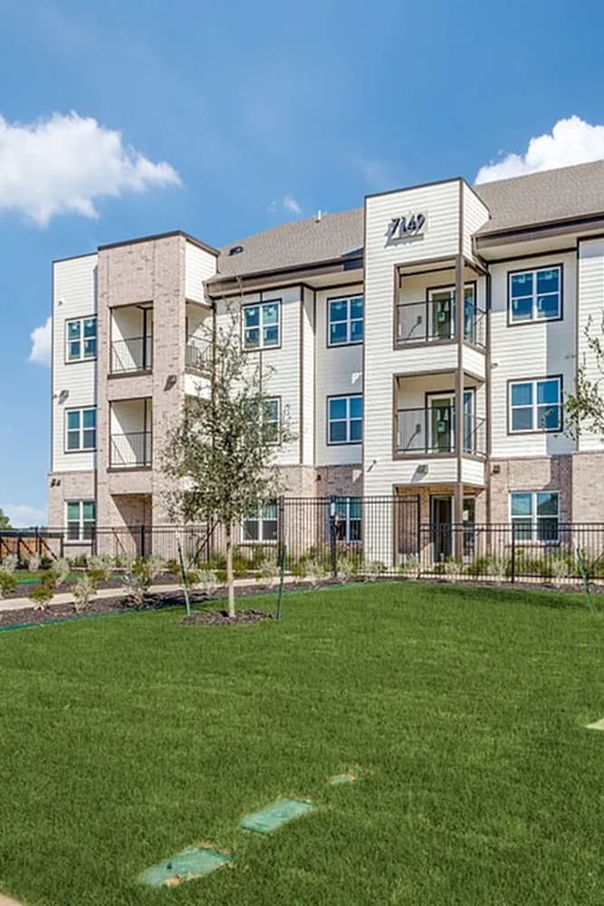 Exterior of apartments with gated electronic entrance at The Trail Lakes in Fort Worth, Texas