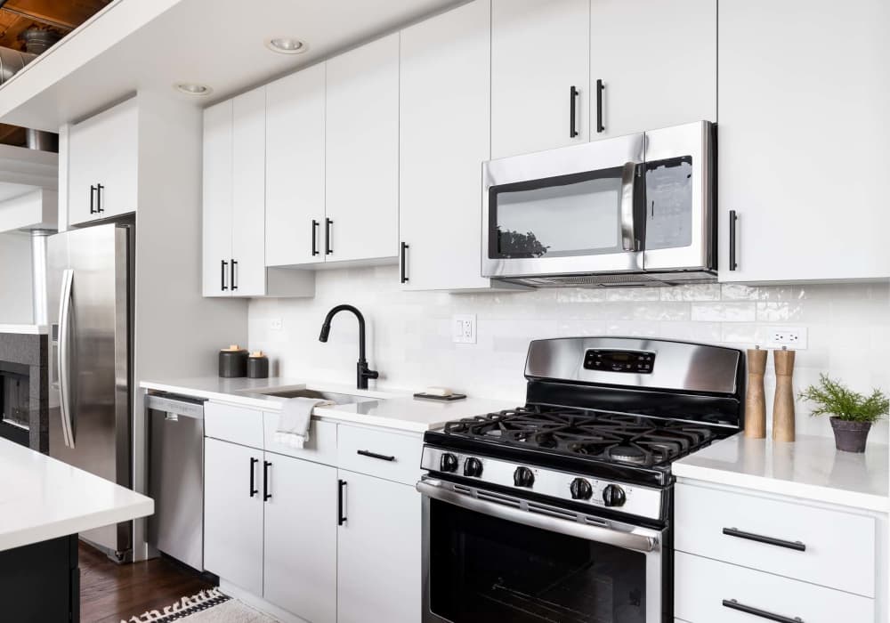 Modern kitchen with stainless-steel appliances and storage spaces at Crystal Commons Townhomes in Gates, New York