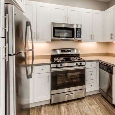 Modern kitchen with stainless-steel appliances in a model home at Sofi Westview in San Diego, California