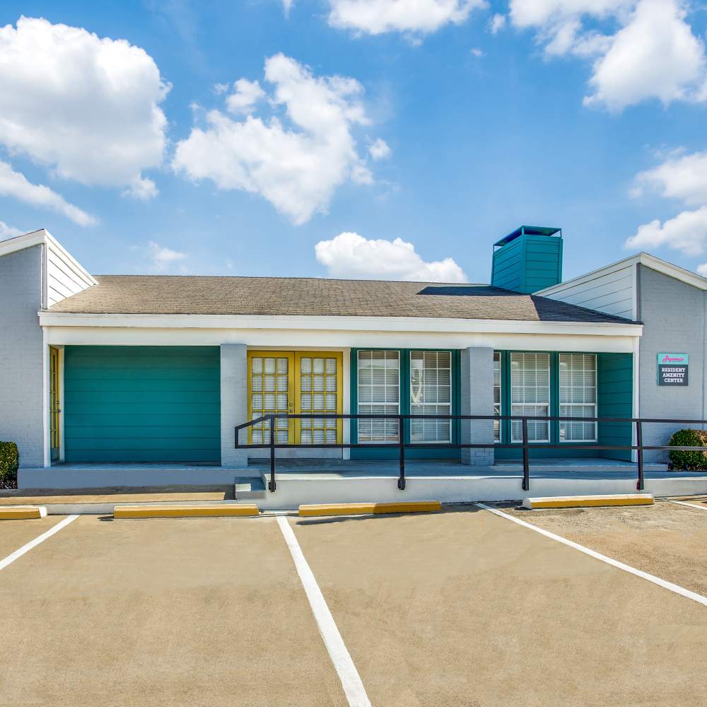 Colorful building exterior with parking at Sagamore Apartments in Benbrook, Texas