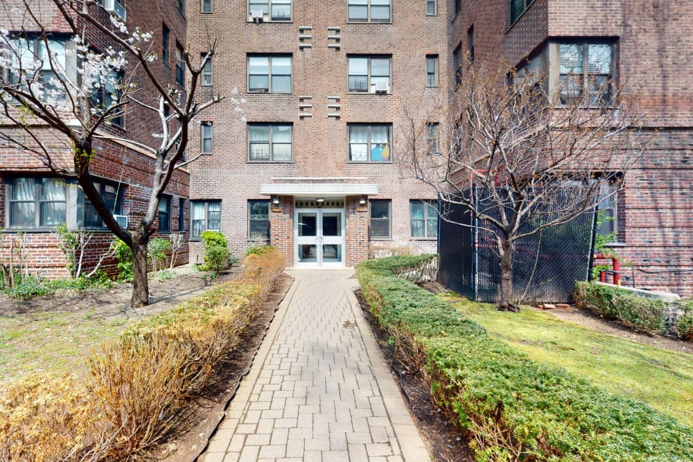 Exterior grass and some trees outside the brick building at Eastgold NYC in New York, New York