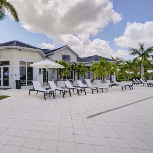 Swimming pool area with lounge beds at Evergreen Estero in Fort Myers, Florida