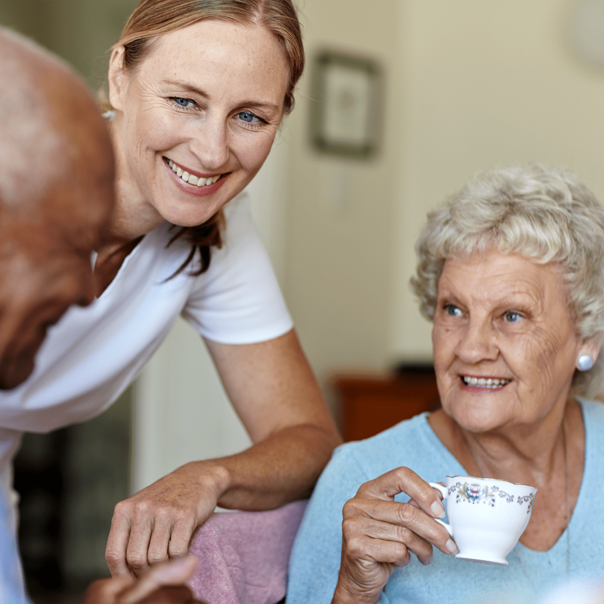 Residents having coffee and talking with an employee at Harmony at Savannah in Savannah, Georgia