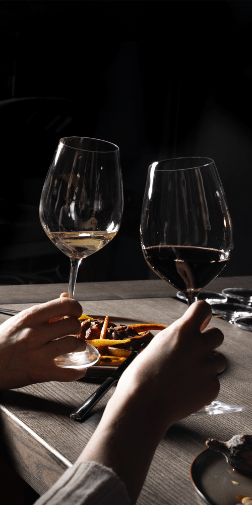 Elegant dinner setting with wine glasses and gourmet dish at Residences at 111 Lyon in Grand Rapids, Michigan