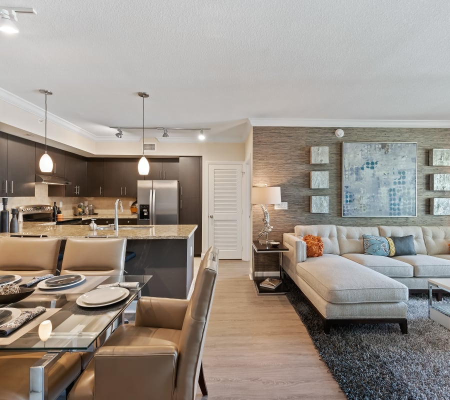 Open concept living room, dining room, and kitchen in a beautiful model apartment home at The Residences at Lakehouse in Miami Lakes, Florida