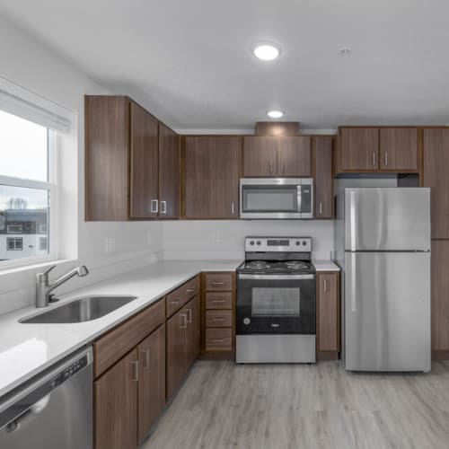 Kitchen with custom cabinetry and stainless-steel appliances at Cherry City Crossing in Keizer, Oregon