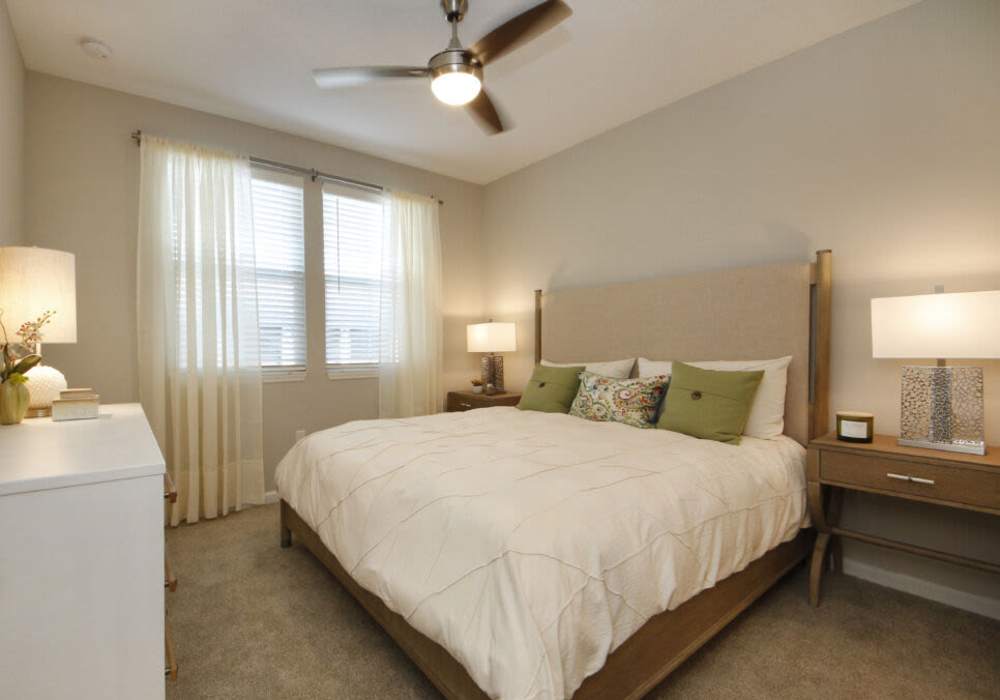 Cozy bedroom with large windows and inviting decor at Messina Luxury Apartments in New Smyrna Beach, Florida