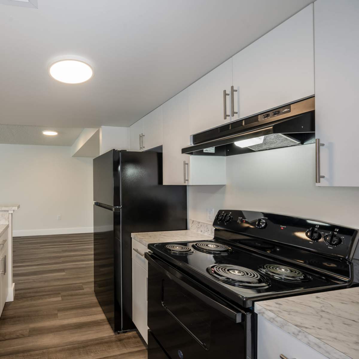 Beautiful kitchen with black appliances and  white cabinetry at Ernie Martin Villas in Miami, Florida