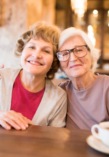 Two resident friends pose for a picture at Claiborne Senior Living. 