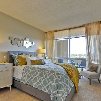 Master bedroom with contemporary decor with balcony access in a model home at The Marc, Palo Alto in Palo Alto, California
