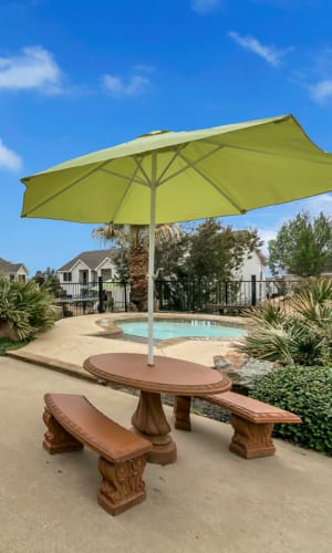 Patio table with an umbrella by the pool at Lakeview in Fort Worth, Texas