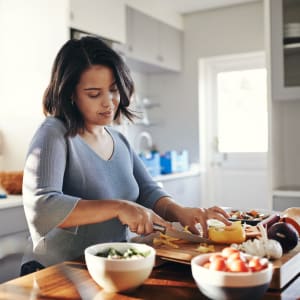 Resident cooking in her well-equipped kitchen at Round Rock Townhomes in Arlington, Texas