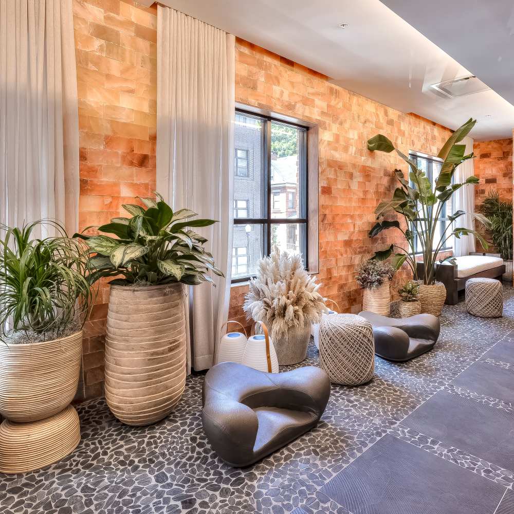 Stylish lounge with vibrant plants and unique seating arrangements at Green|House Columbus in Columbus, Ohio