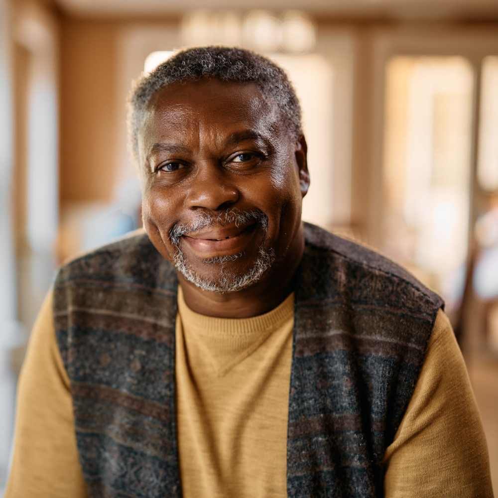 Warm lighting highlights smiling man indoors at The Simone in Silver Spring, Maryland