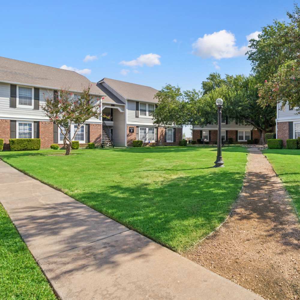 Exterior shot of the apartments with walking trails at Arbors of Taylor in Taylor, Texas