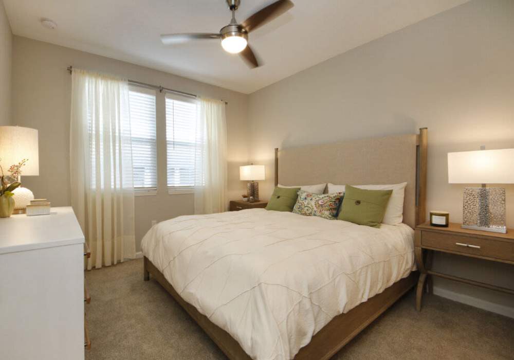 Model bedroom with wood-style flooring at Messina Luxury Apartments in New Smyrna Beach, Florida