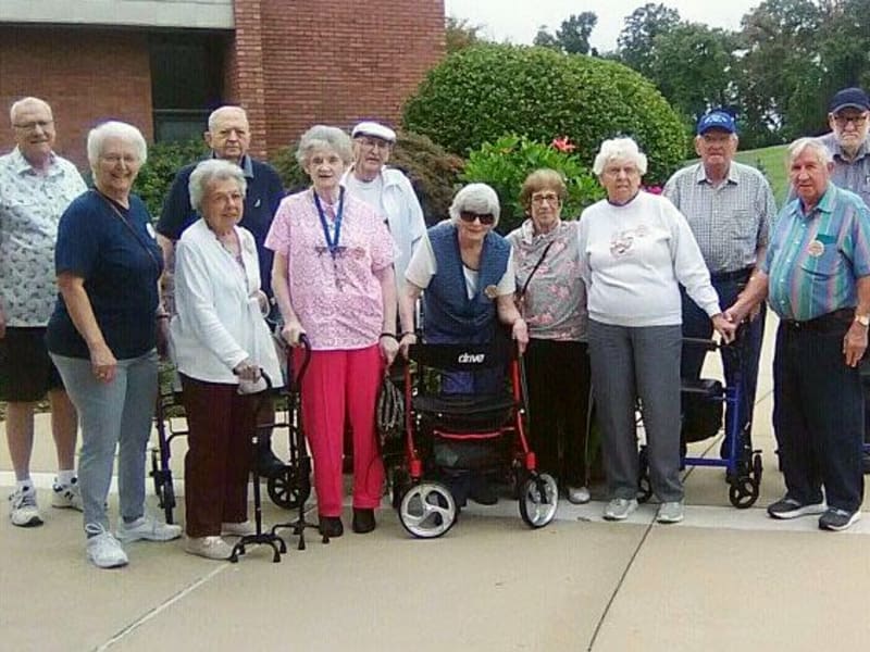 Group of smiling residents in front of Garden Place Waterloo in Waterloo, Illinois. 