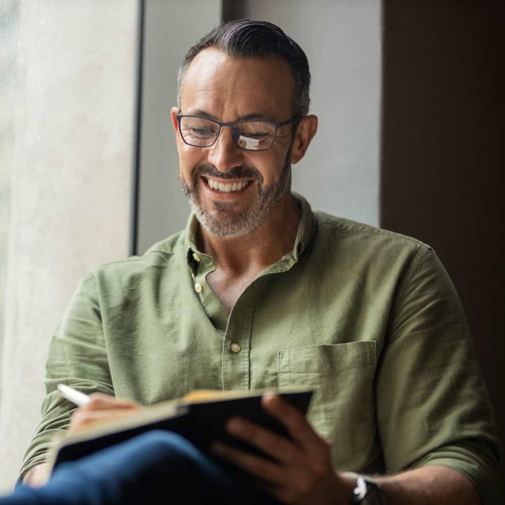 Happy resident reading book at Camino Al Oro in Los Angeles, California