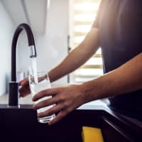 Man filling up water glass at Birch Apartment Homes in Dallas, Texas