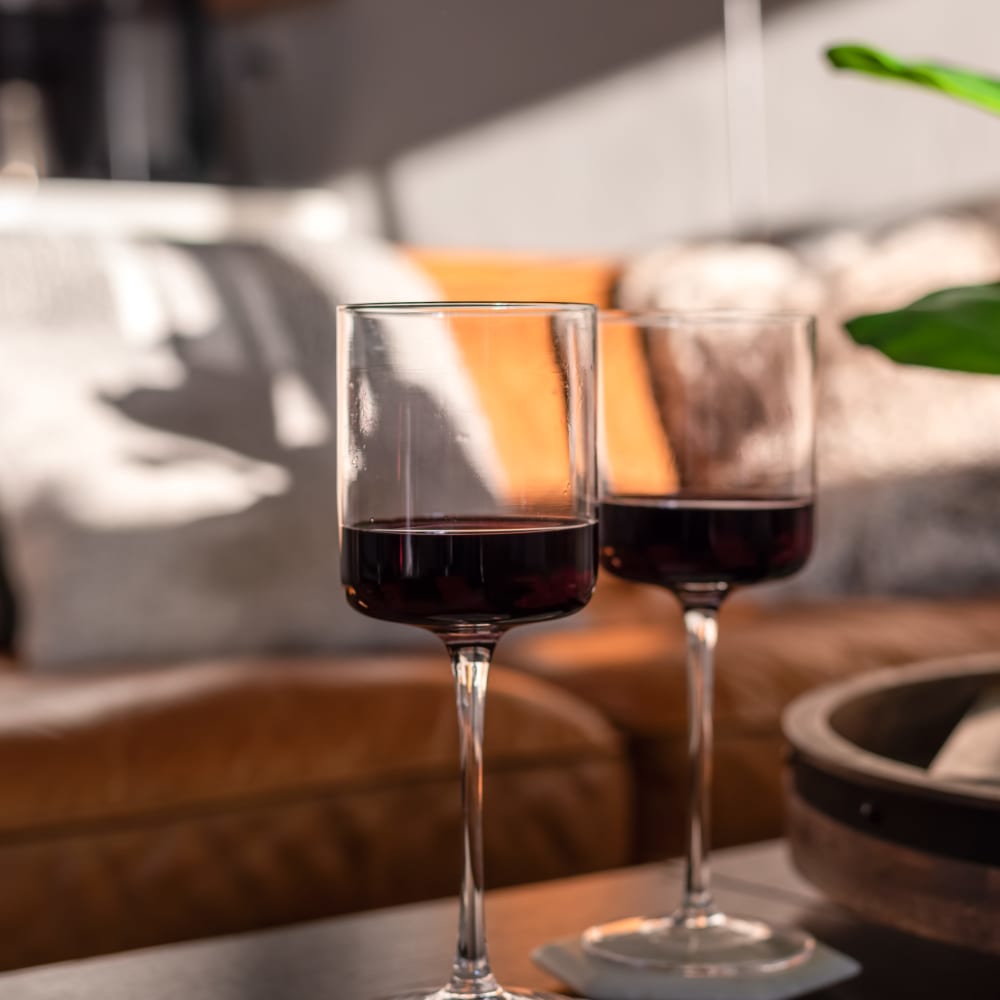 Wine glasses with sofa in back at  Lafayette Oaks in Lafayette, California