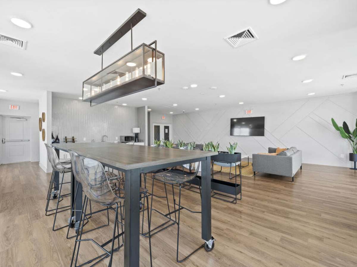 Common area with large dining table and hanging light at The Rise at Regency in Henrico, Virginia