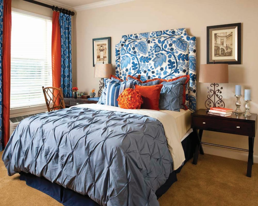 Bedroom at Isle at Cedar Ridge in Cedar Park, Texas, with vibrant blue and orange decor and bedding.