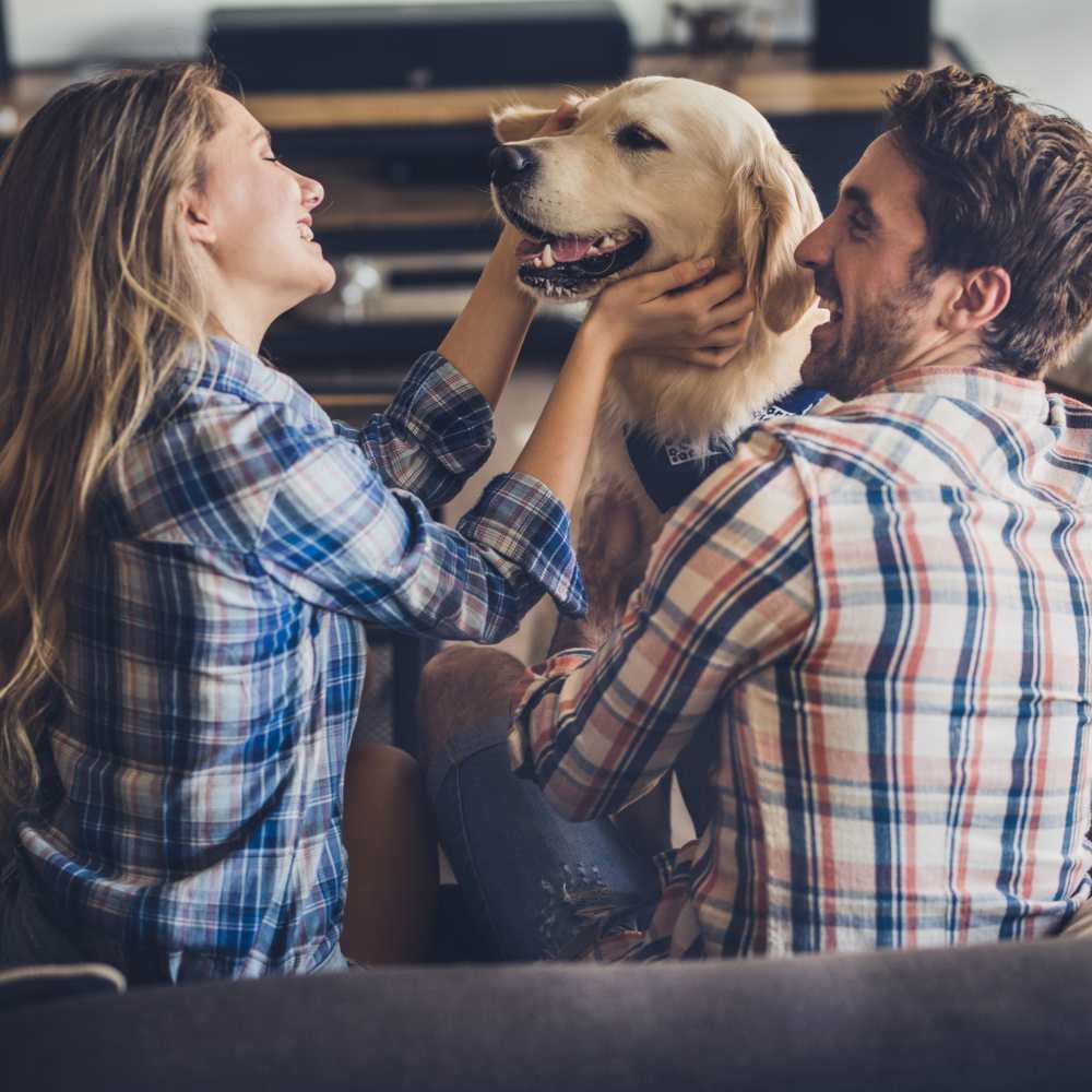 Residents with their dog in the living room at The Elms at Germantown in Germantown, Maryland