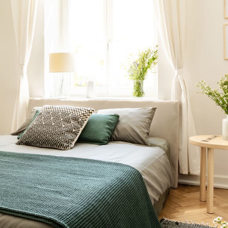 Model bedroom with blue accents at Burrell Square in Rome, Georgia