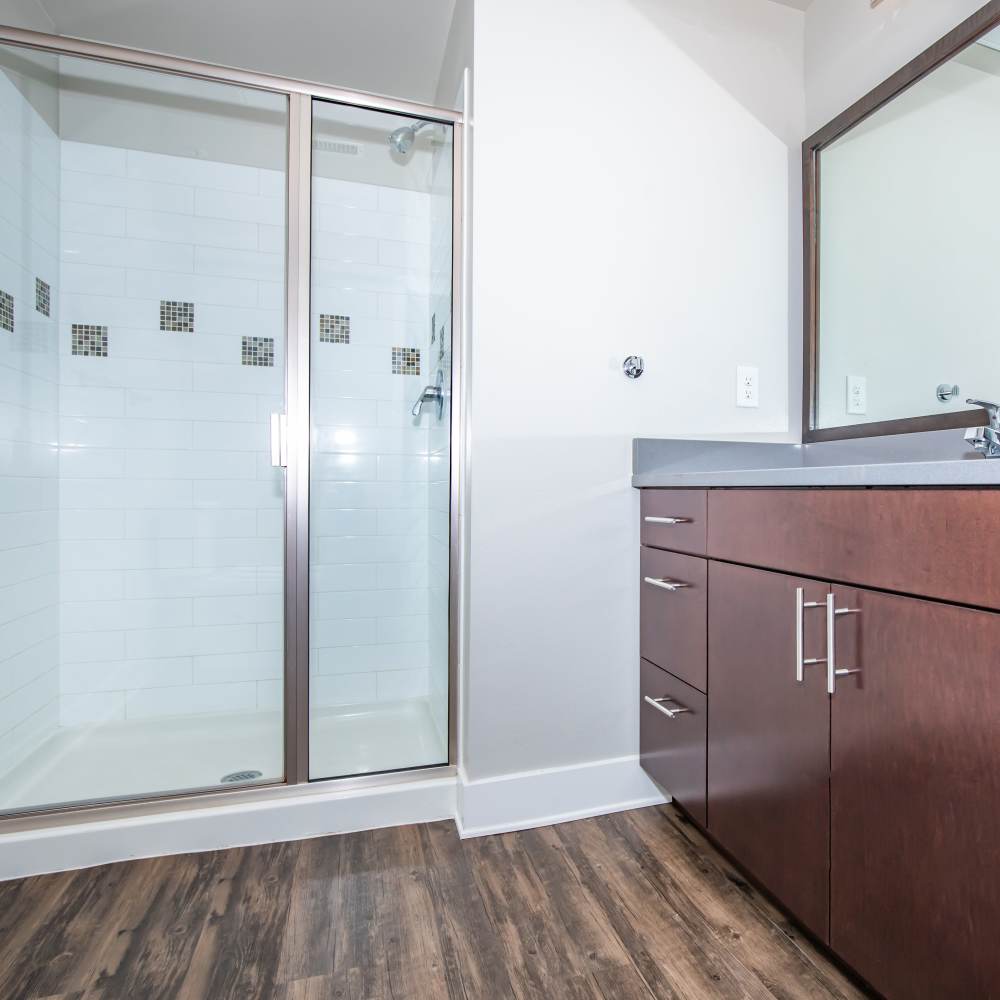 Bathroom with mirror, sink and glass shower at Park Place Olde Town Apartments in Arvada, Colorado