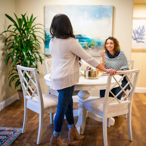 Residents socializing in the dinning room with beautiful hardwood flooring at San Hacienda in Chandler, Arizona