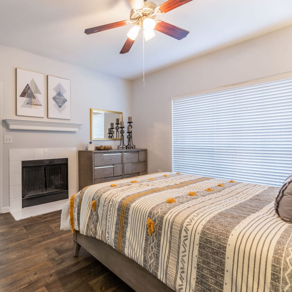 Resident bedroom with wood-style flooring at The Gentry in Houston, Texas