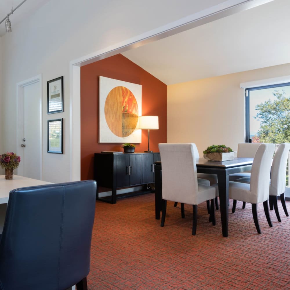 Open-concept living and dining areas and plush carpeting in a model home at Skyline Redmond in Redmond, Washington