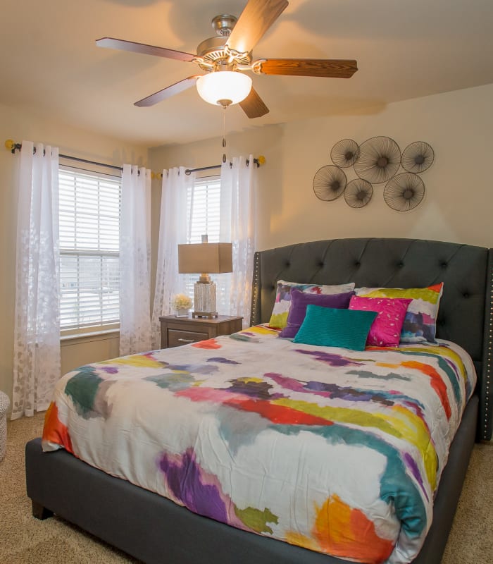 Chic bedroom with ceiling fan at Portofino Apartments in Wichita, Kansas