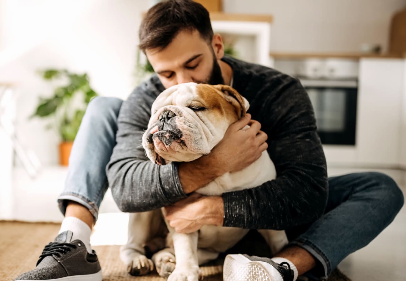 Man kissing dog at Holbrook Apartment Homes in Dallas, Texas