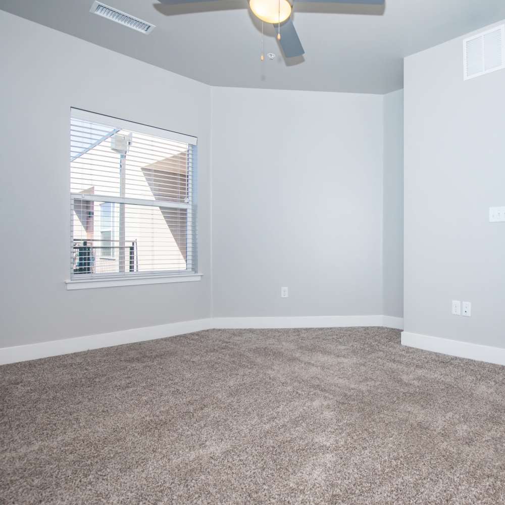 Unfurnished bedroom with large window and ceiling fan at Park Place Olde Town Apartments in Arvada, Colorado