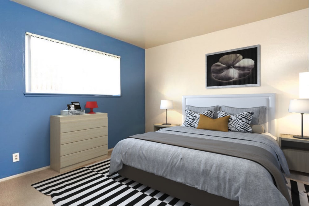 Comfy queen bed in primary bedroom at Coral Gardens Apartments in Hayward, California