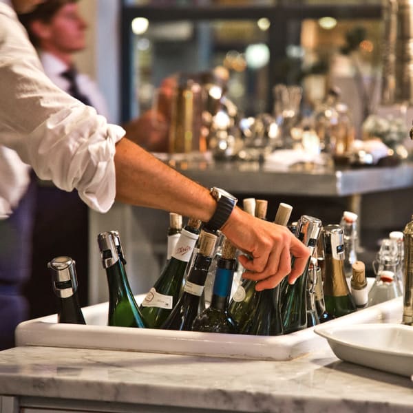 Server selecting wine near The Wave at Stadium Place in Seattle, Washington