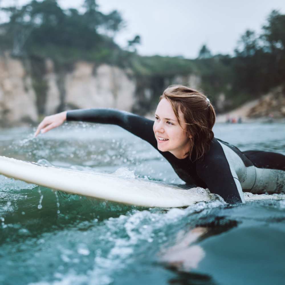Surfer reaching for a white surfboard at Dolphin Marina Apartments in Marina Del Rey, California