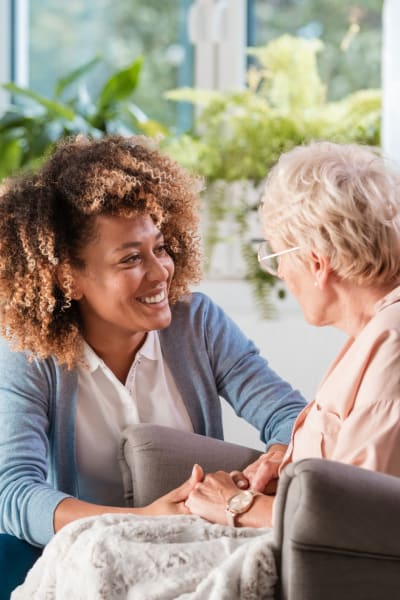 Young woman talking to a resident at Quail Park of Lynnwood in Lynnwood, Washington