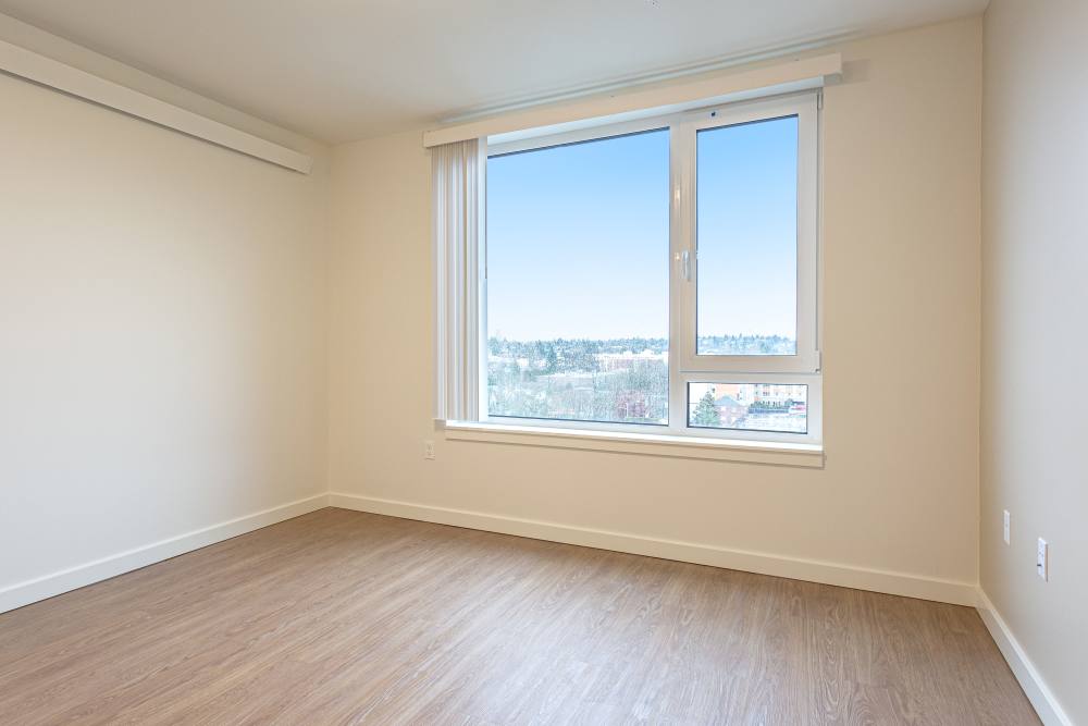 Spacious bedroom with plank flooring at Gardner House in Seattle, Washington