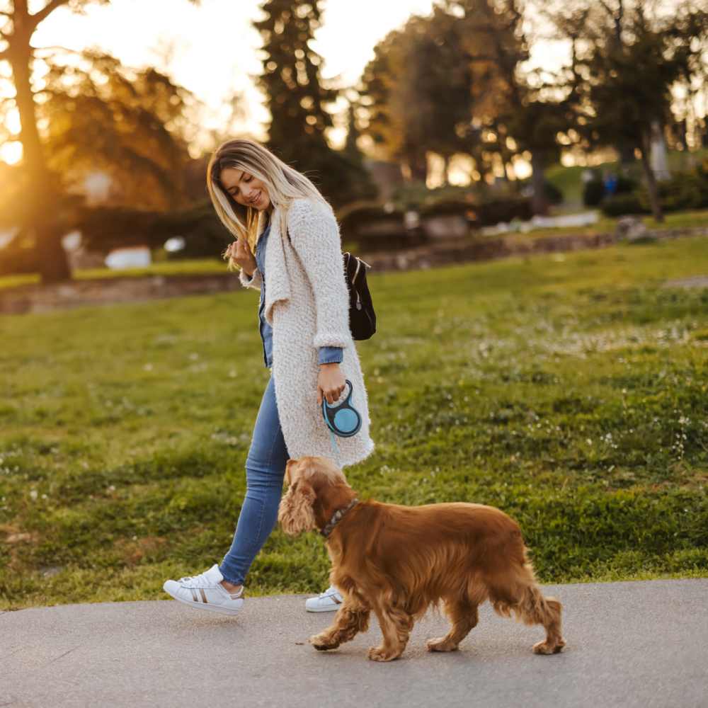 Woman out for a walk along with her dog near The Elms at Kendall Ridge in Columbia, Maryland