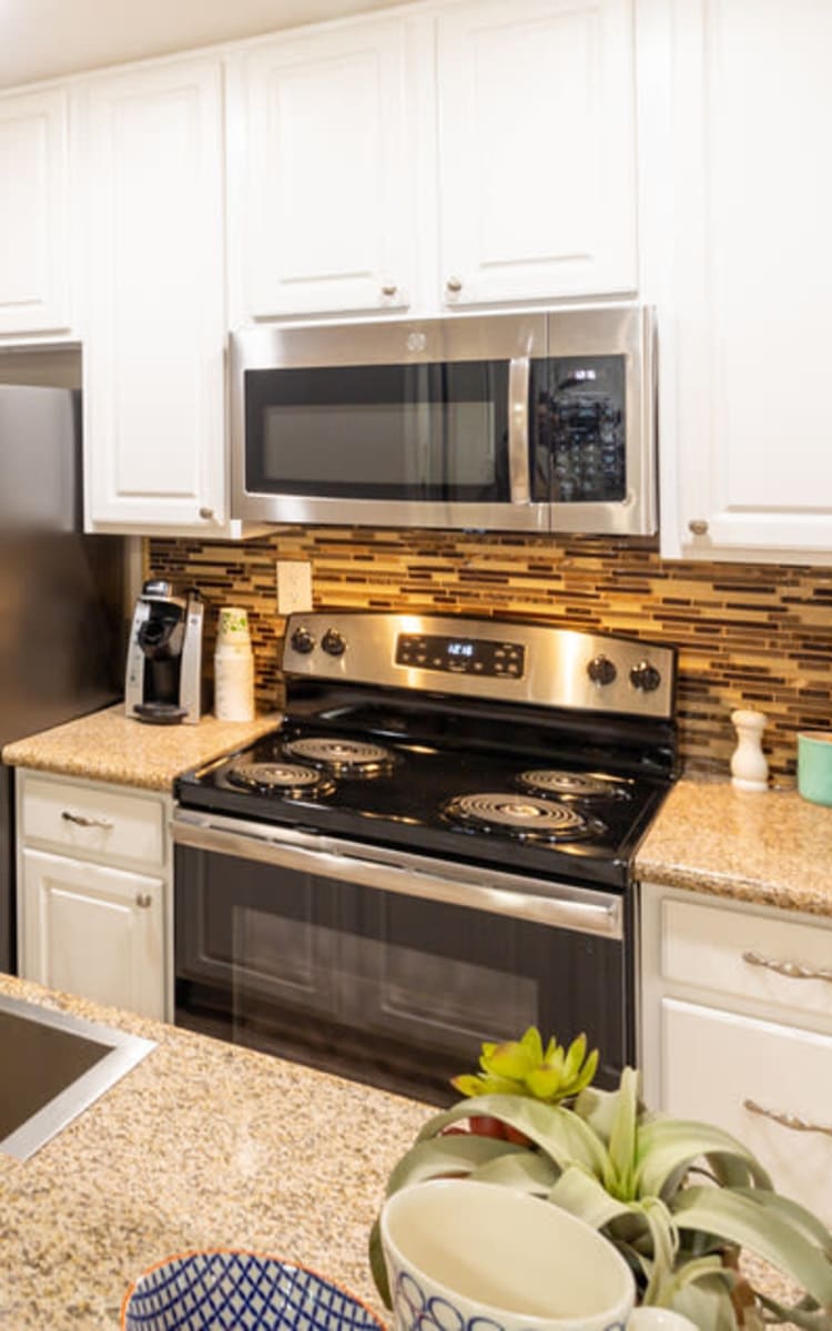 Modern kitchen with sleek, stainless-steel appliances in a model home at Haven Warner Center in Canoga Park, California
