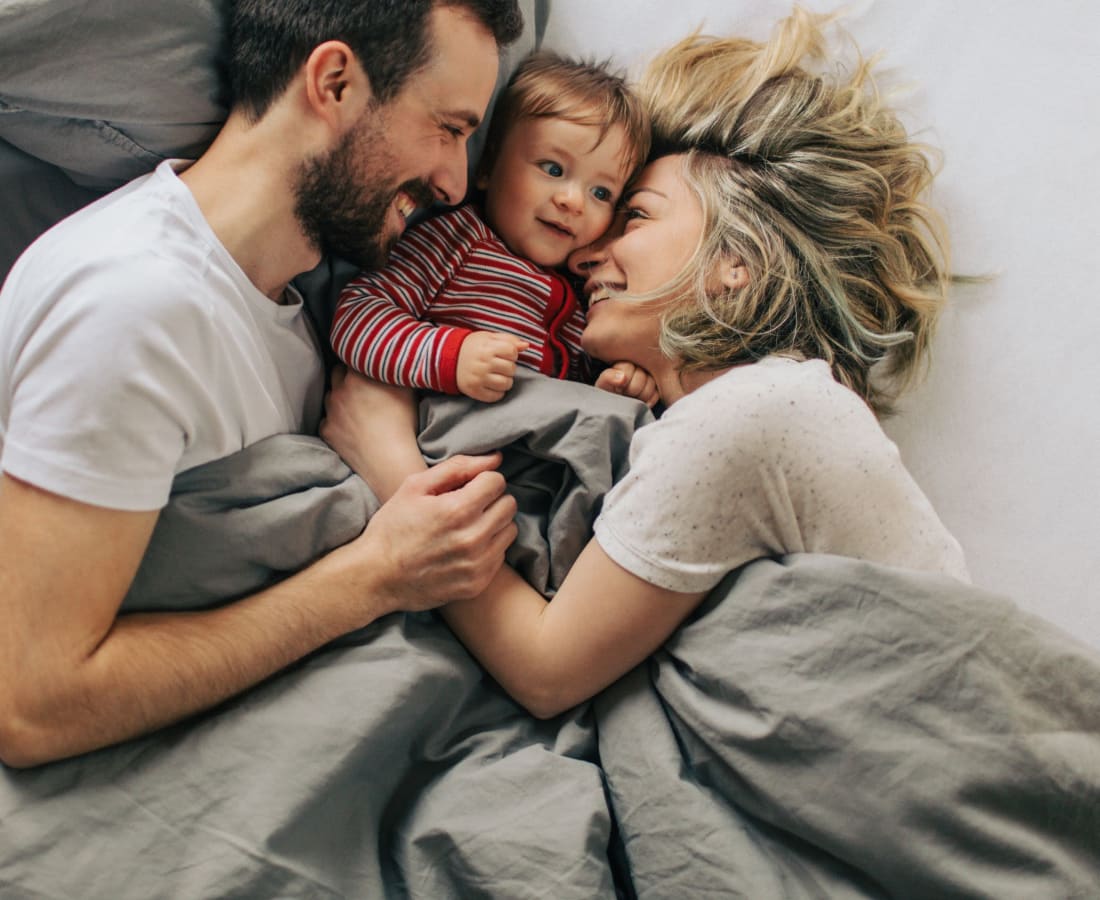 Family cuddling in bed at High Range Village in Las Cruces, New Mexico