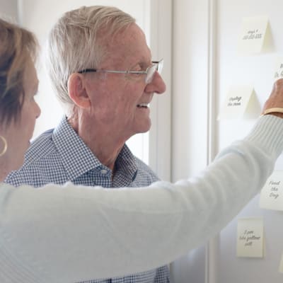 Resident looking at to-do stickynotes with a caretaker at York Gardens in Edina, Minnesota