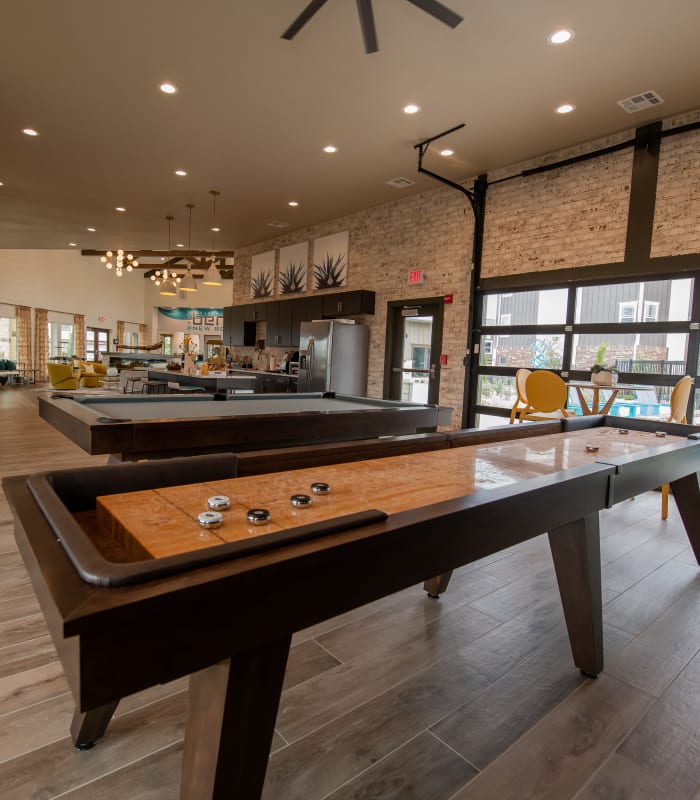 Clubhouse with shuffleboard of Bend at New Road Apartments in Waco, Texas