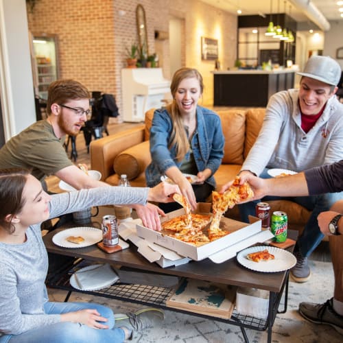 Residents eating pizza in the community clubhouse at West Towne in Ames, Iowa